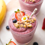 side angle view of healthy chia smoothie with straw and items surrounding.
