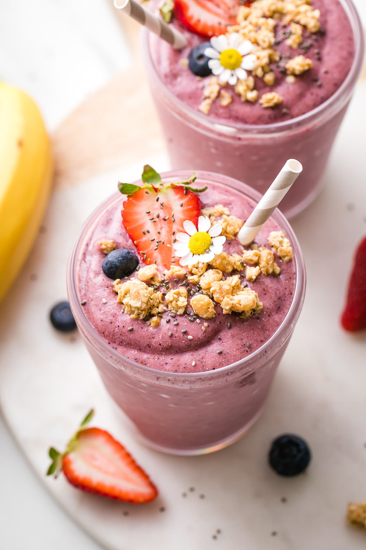 side angle view of chia seed smoothie in a glass with toppings.