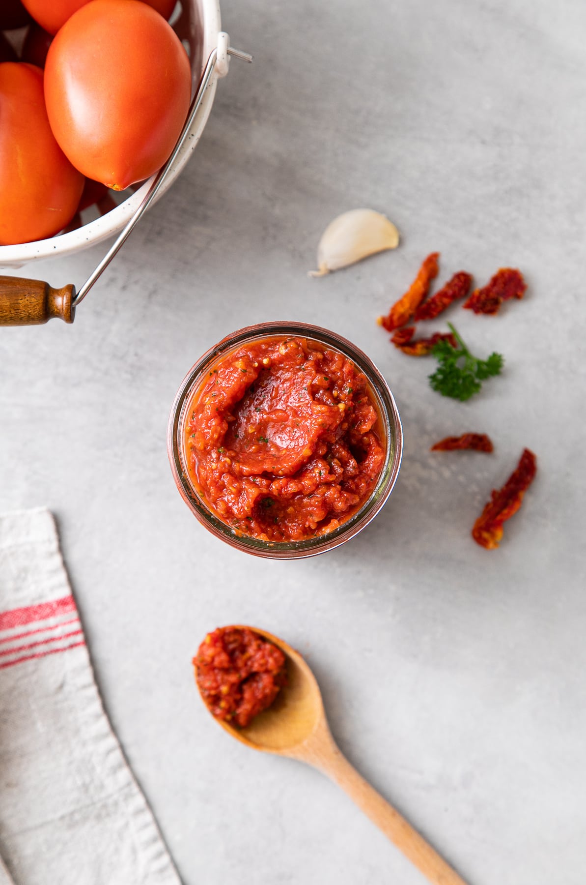 top down view of raw marinara sauce in glass jar with items surrounding.