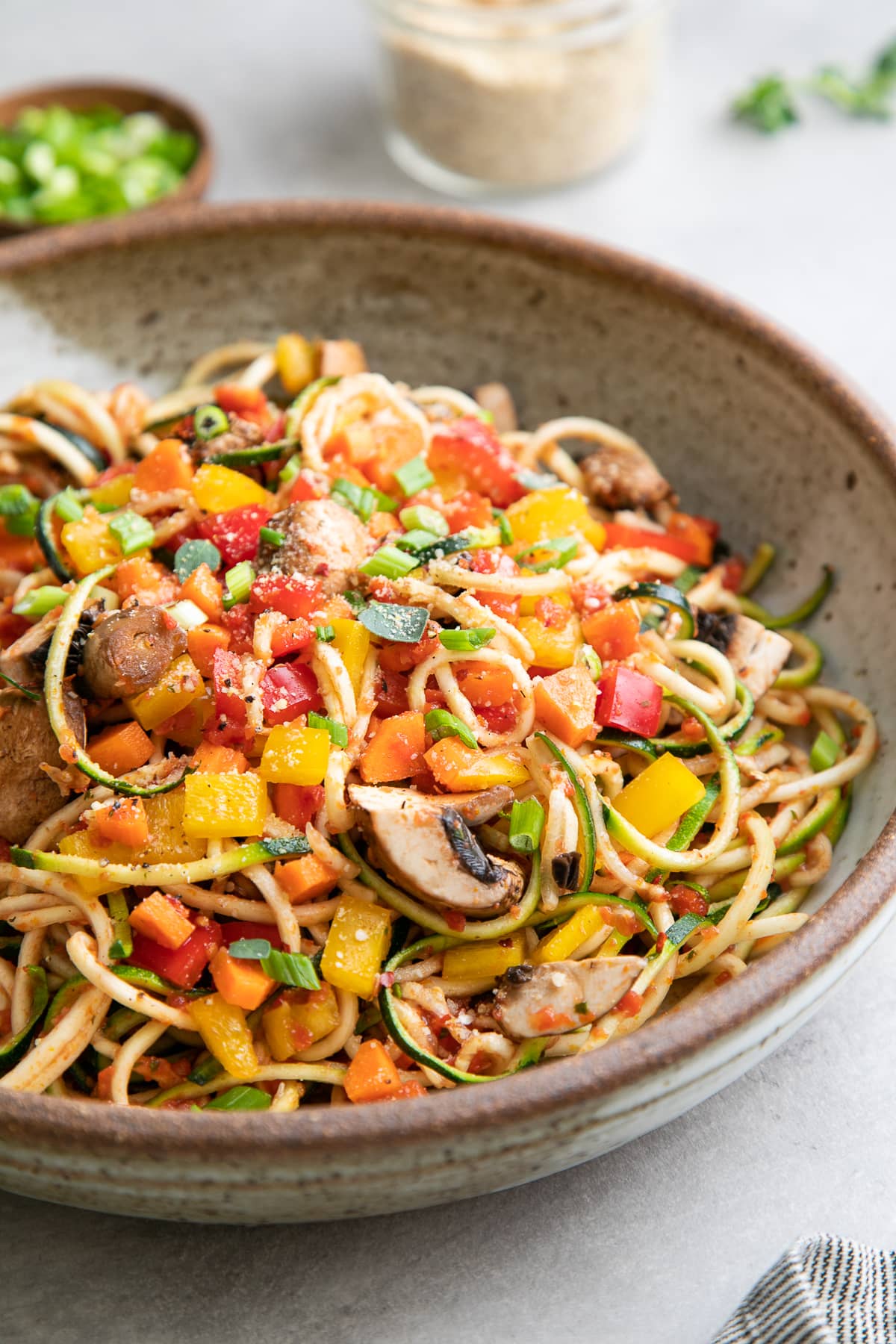 side angle view of plated raw vegetable pasta.