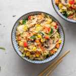top down view of vegetable quinoa fried rice in a blue and white bowl.