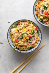 top down view of vegetable quinoa fried rice in a blue and white bowl.
