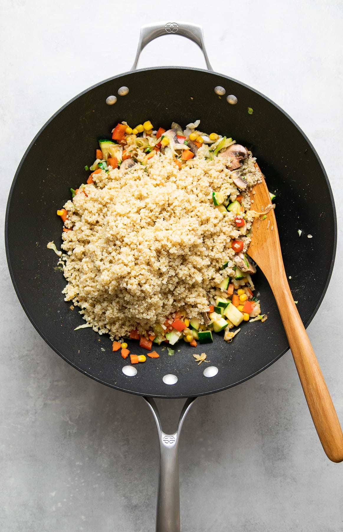 top down view of quinoa added to stir fried veggies to make quinoa fried rice.