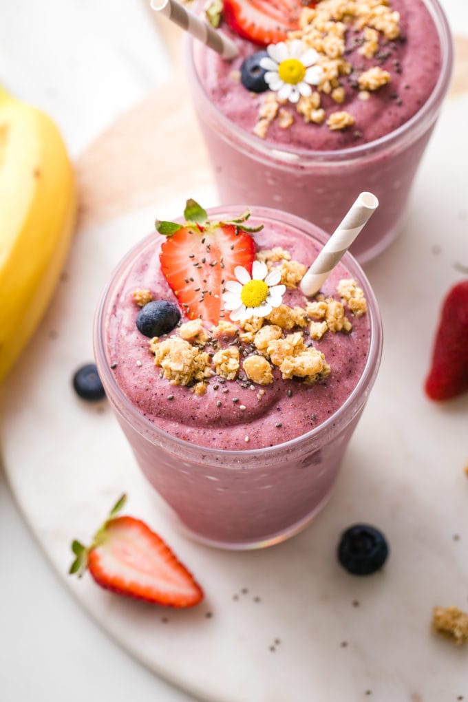 side angle view of healthy chia smoothie with straw and items surrounding.