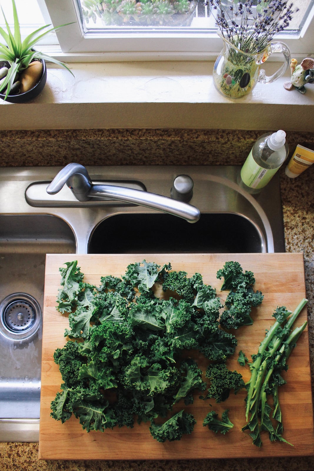 top down view of kale being prepped on a wooden cutting board.