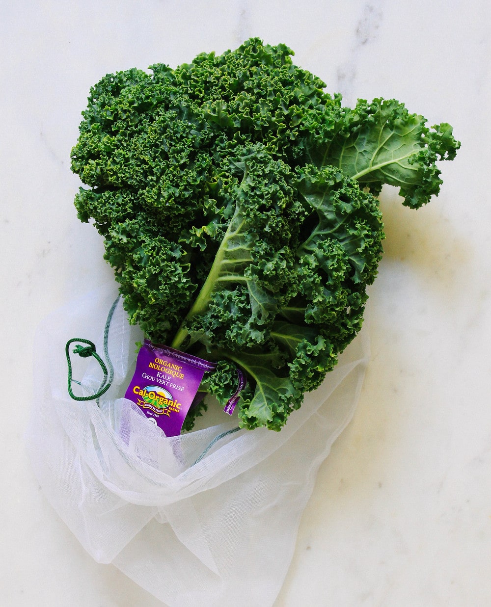 curly kale sticking out of a produce bag