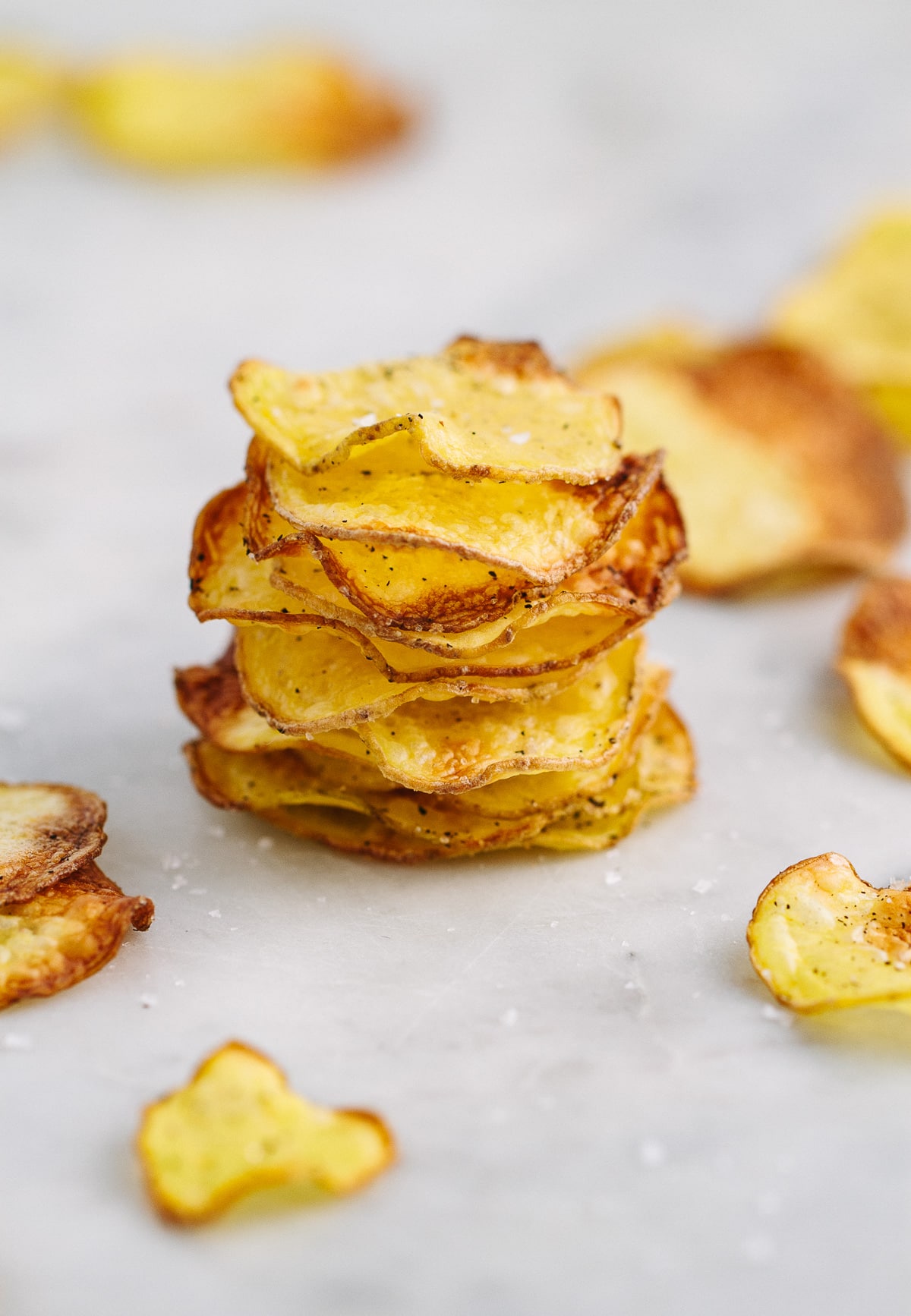 head on view of homemade baked potato chips stacked on top of each other.