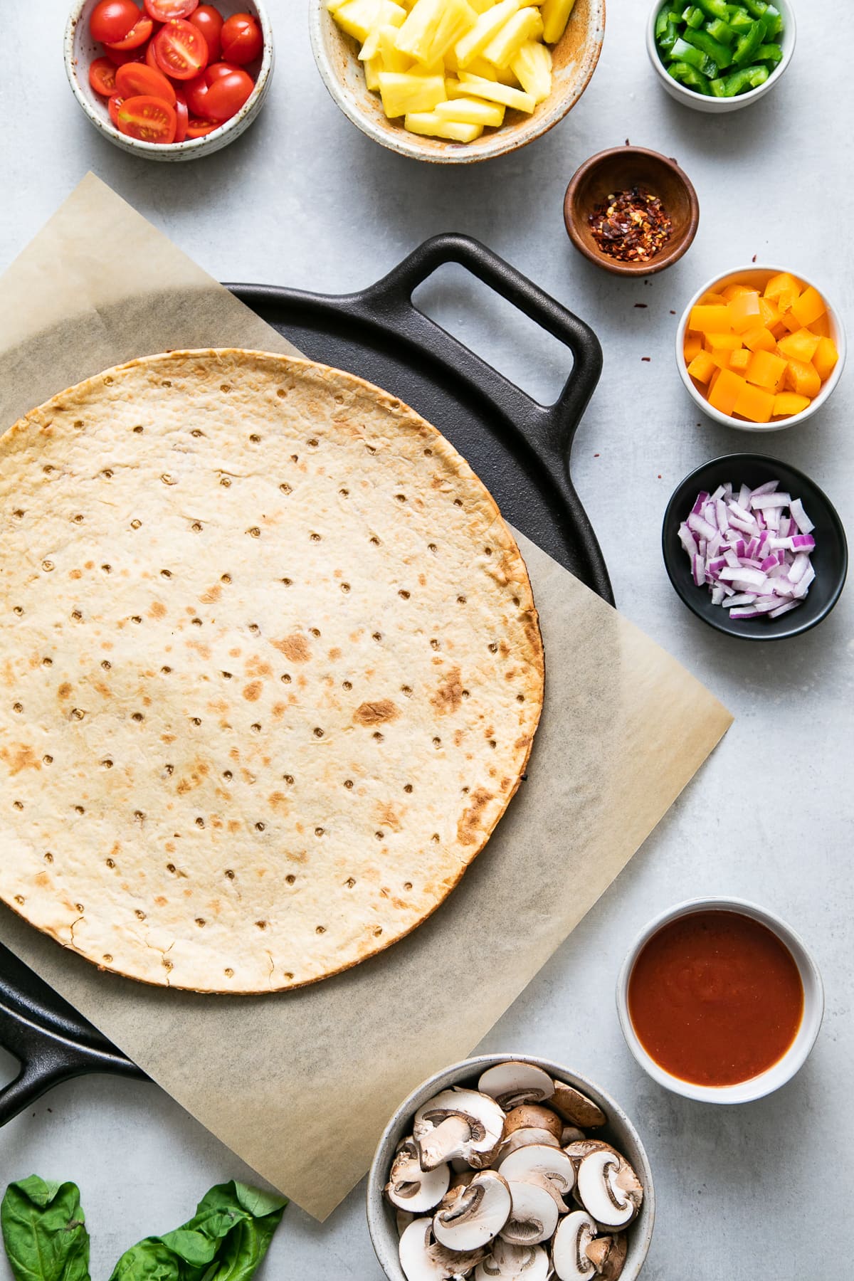 top down view of ingredients used to make pineapple veggie lovers pizza.