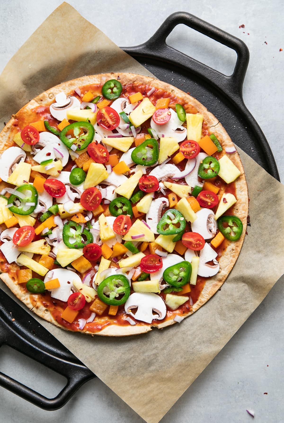 top down view of pineapple veggie lovers pizza just before going into the oven to bake.