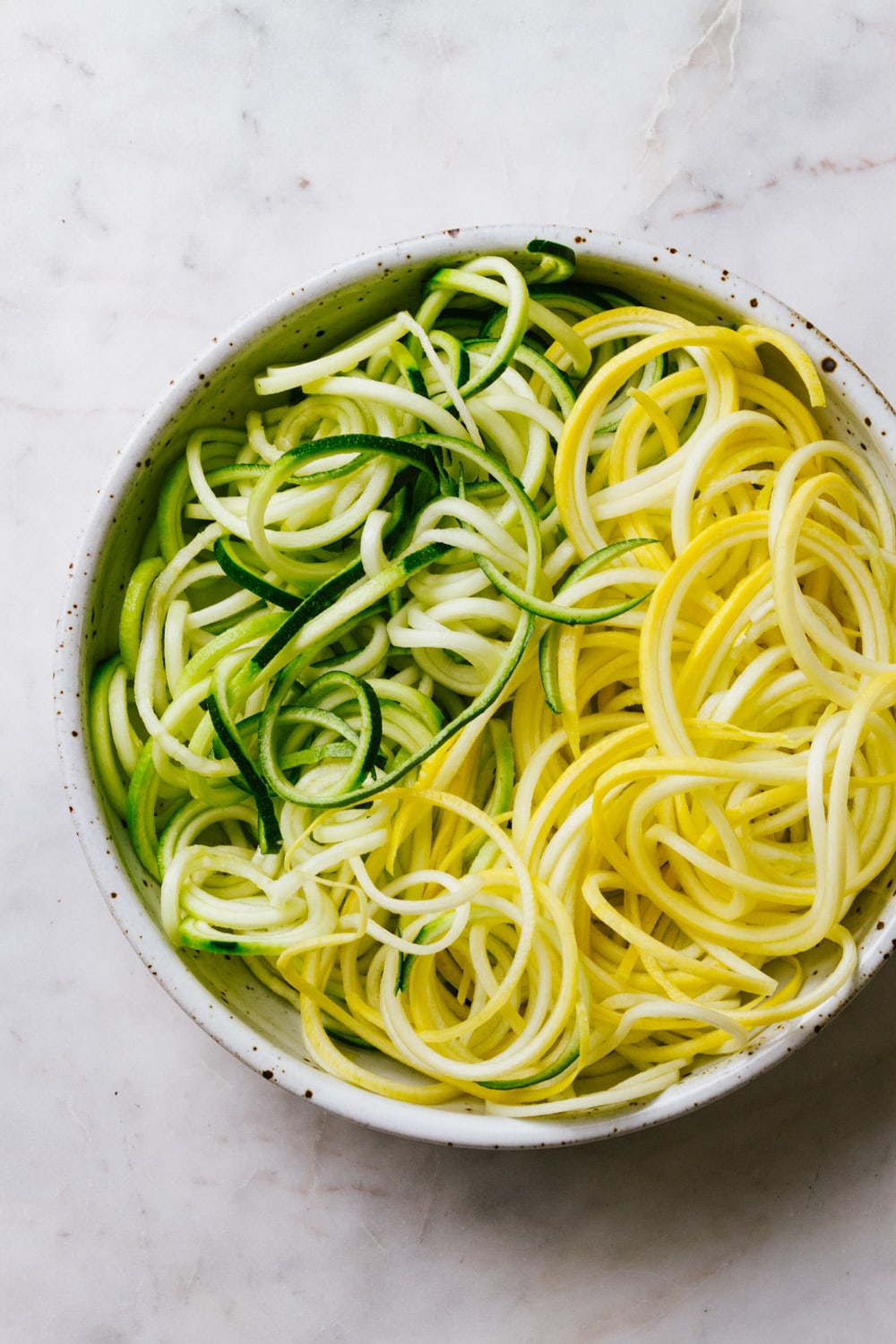 zucchini and yellow squash noodles in a bowl