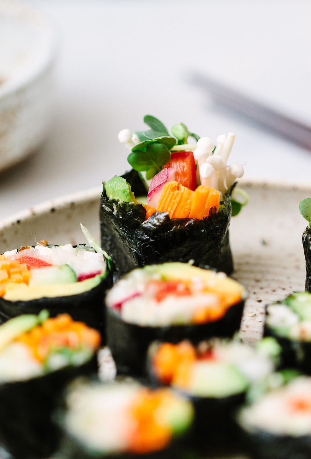 side angle view of sliced vegan sushi roll on a plate