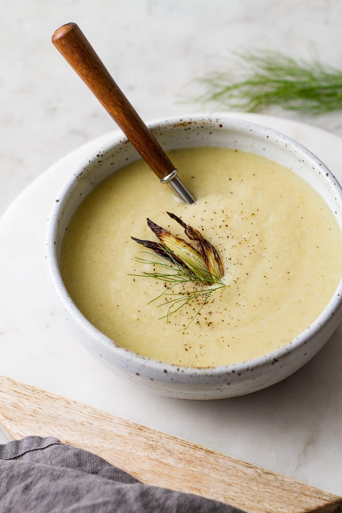 side angle view of a bowl full of roasted fennel and potato soup.