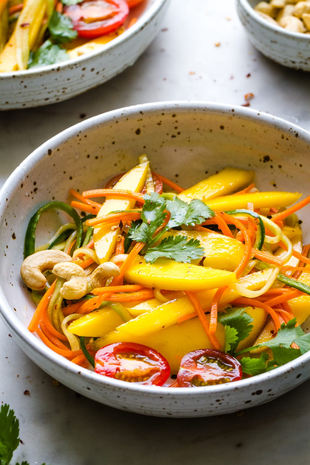 side angle view of bowl with a serving of spicy thai mango salad