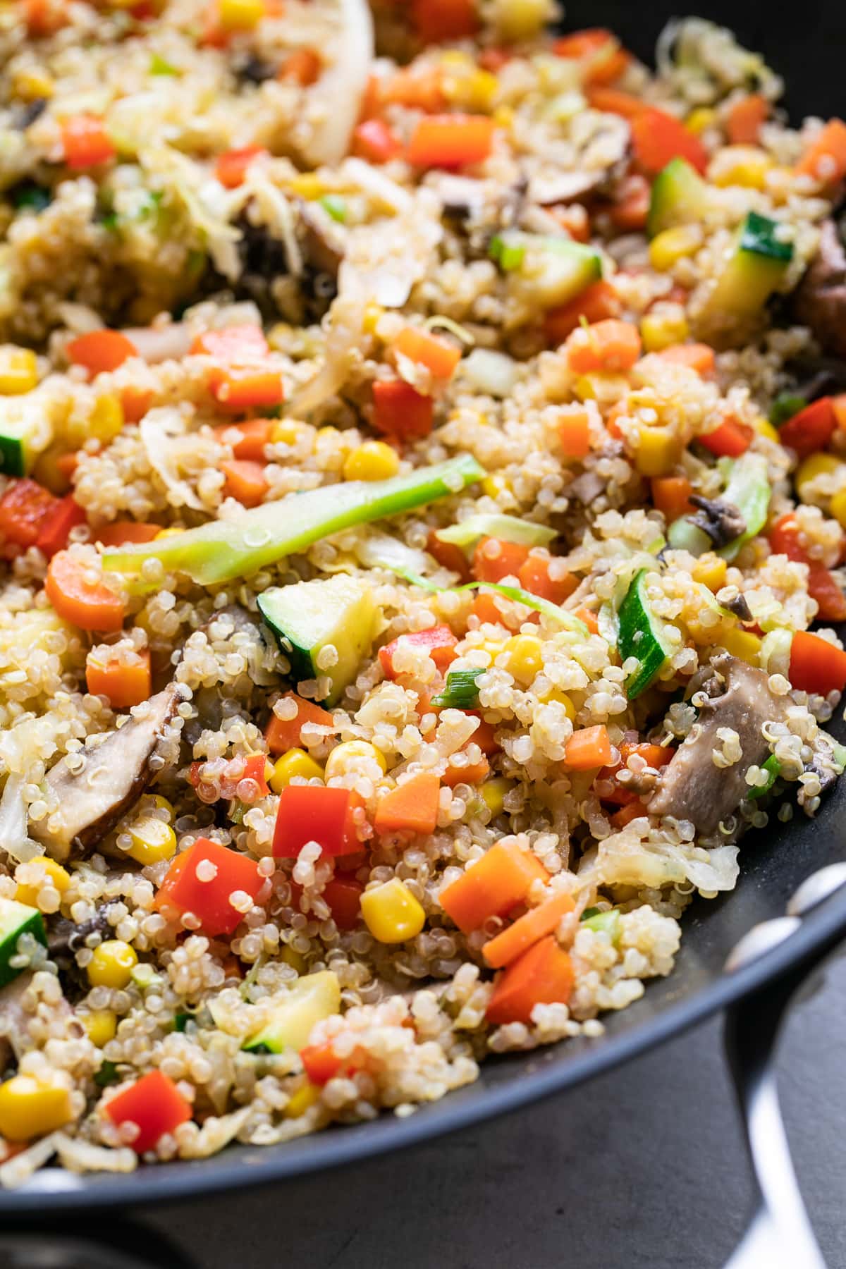 side angle view of freshly made quinoa fried rice in a wok.