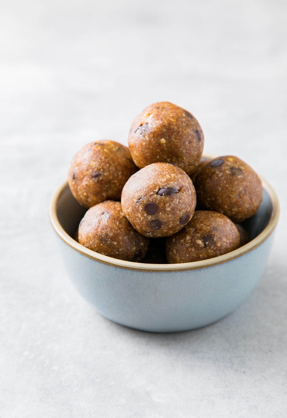 side angle view of chocolate chip energy bites in a small bowl.