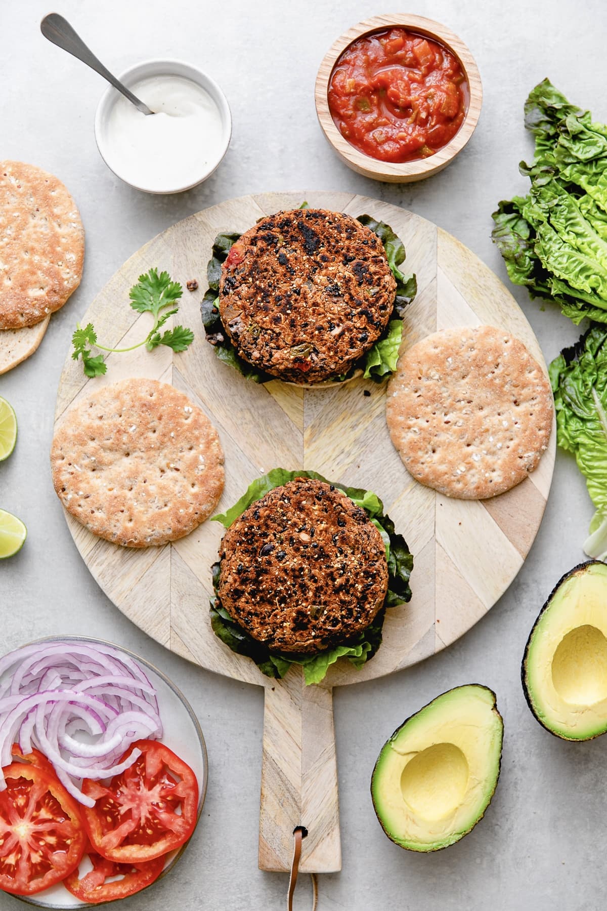 top down view of black bean burgers with toppings surrounding.