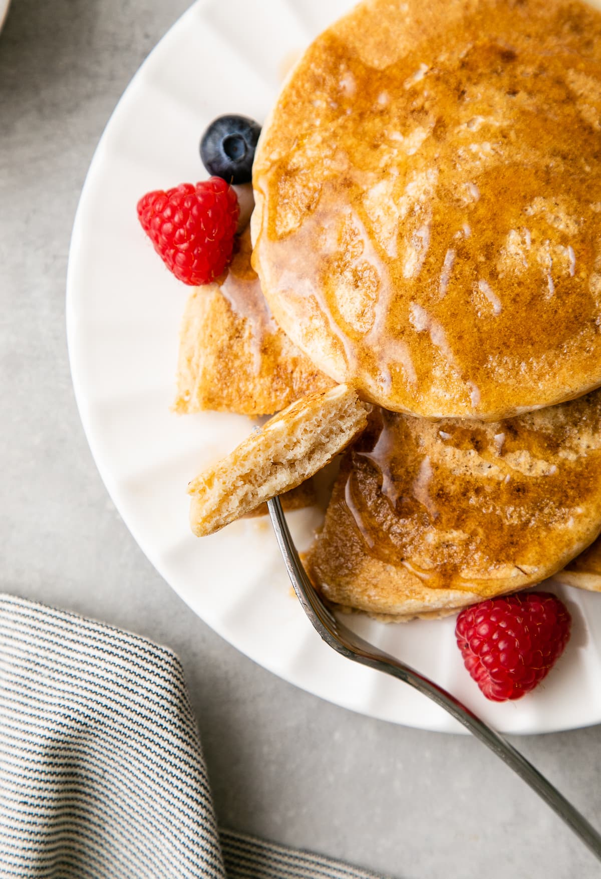 top down view of fork with bite of light and fluffy vegan pancakes.