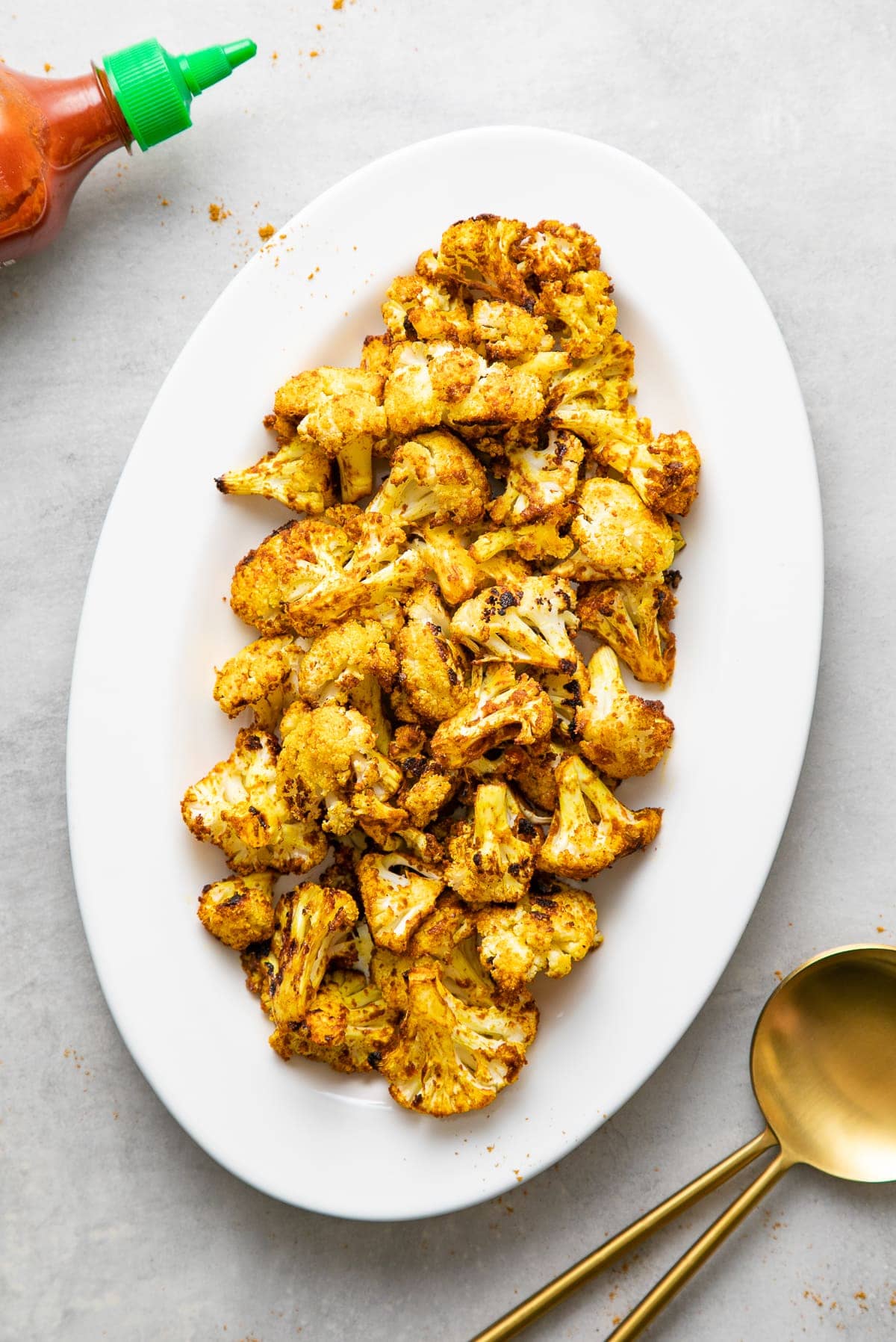top down view of a serving platter with freshly made curry sriracha roasted cauliflower.