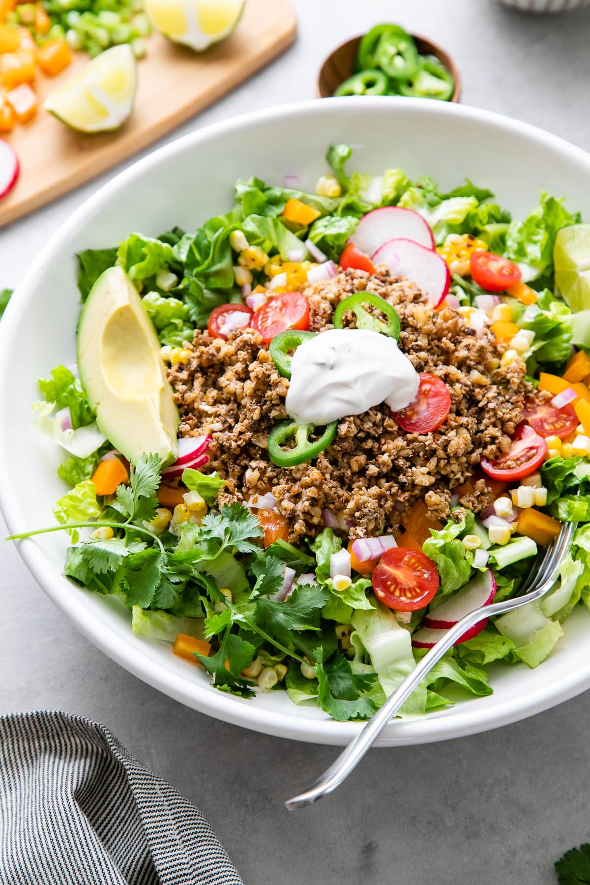 side angle view of healthy vegan taco salad with items surrounding.