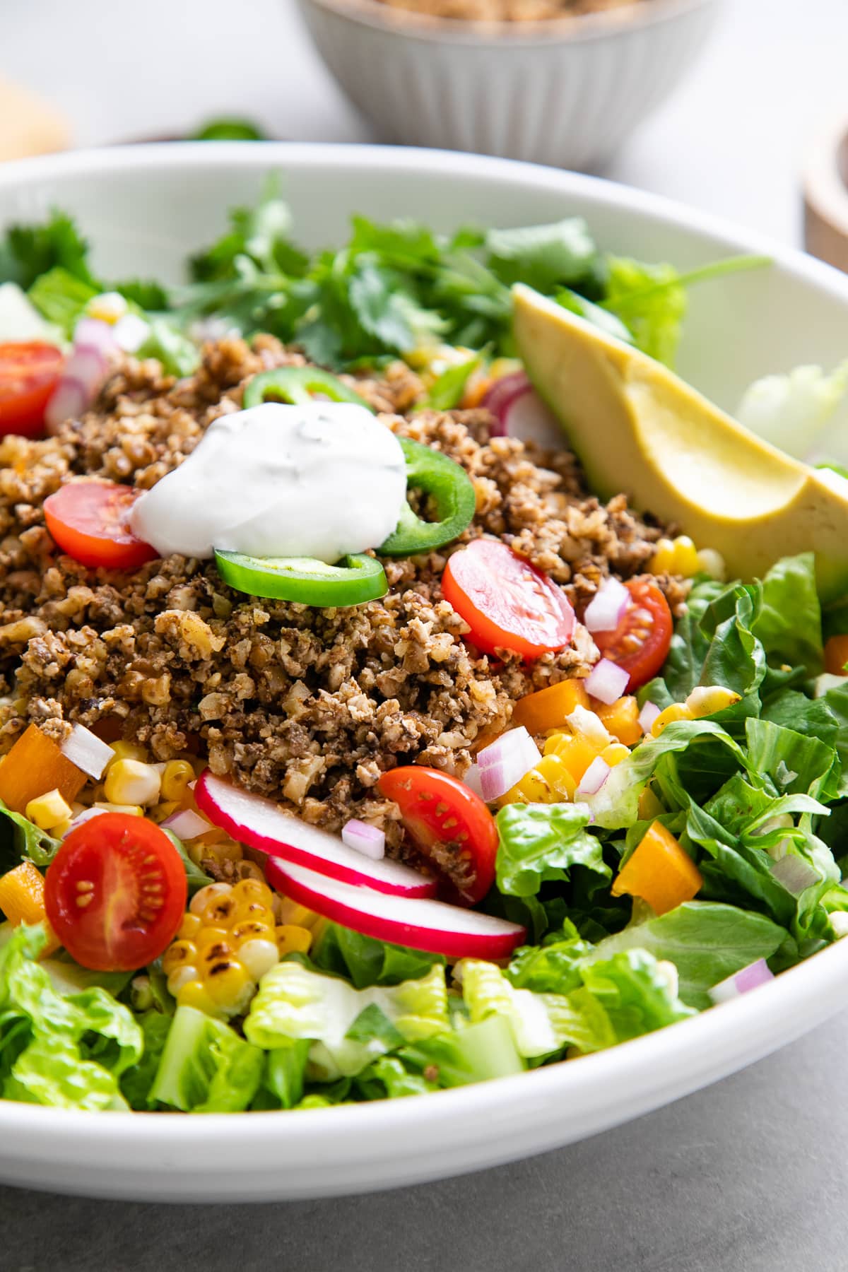 side angle view of healthy taco salad in a white bowl.