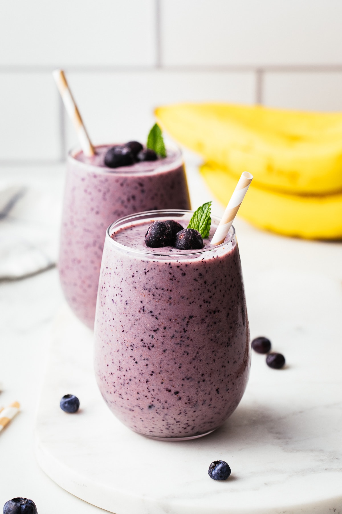 head on view of healthy blueberry banana smoothie in a glass.
