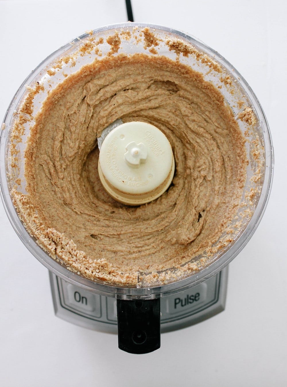 top down view of homemade almond butter after processing in a food processor for about 15 minutes, beginning to become smooth