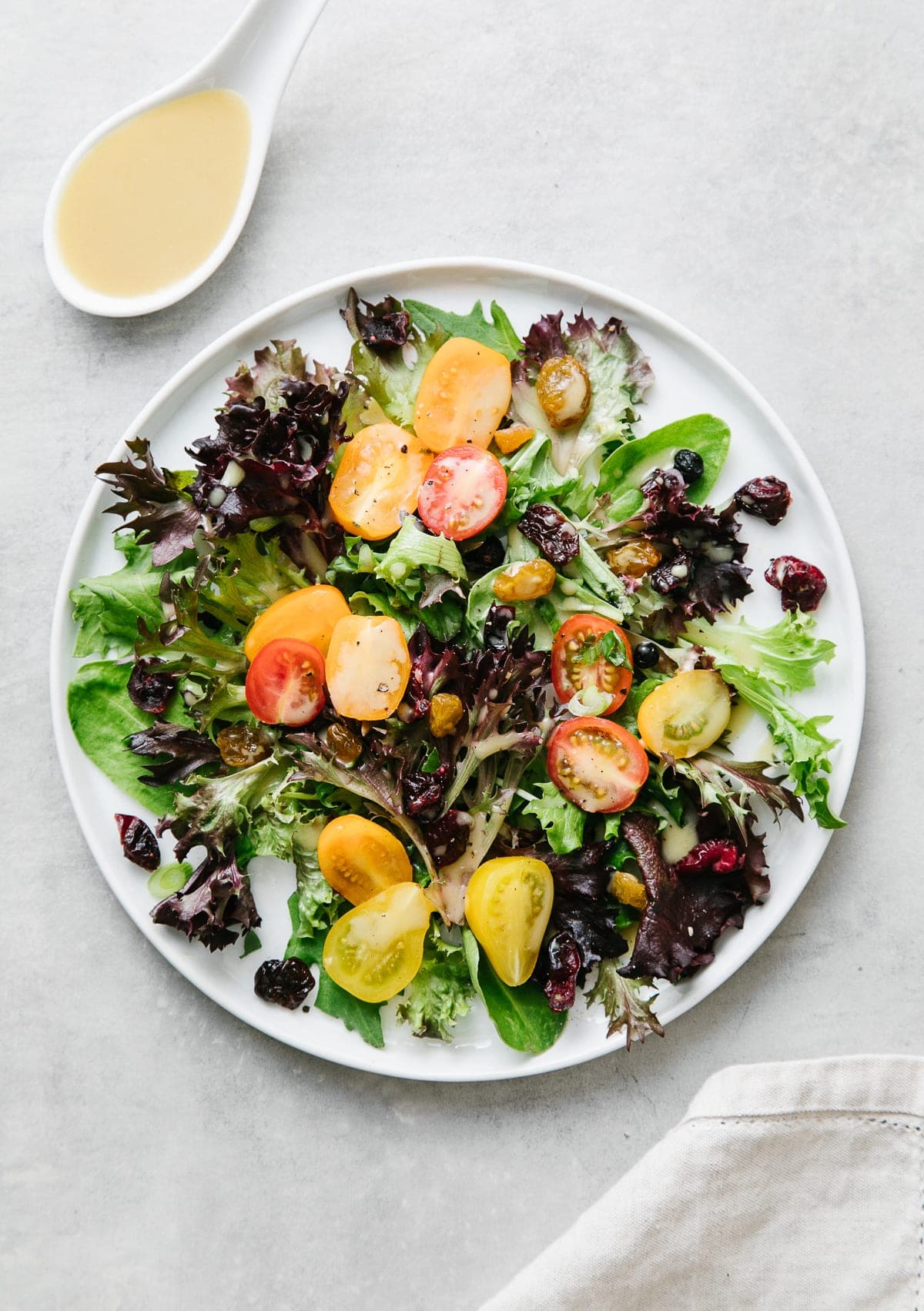top down view of a salad with healthy maple dijon dressing with items surrounding.