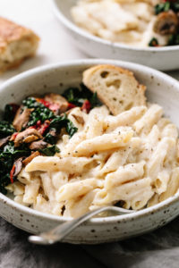 creamy white bean and cauliflower alfredo sauce with penne pasta in a bowl