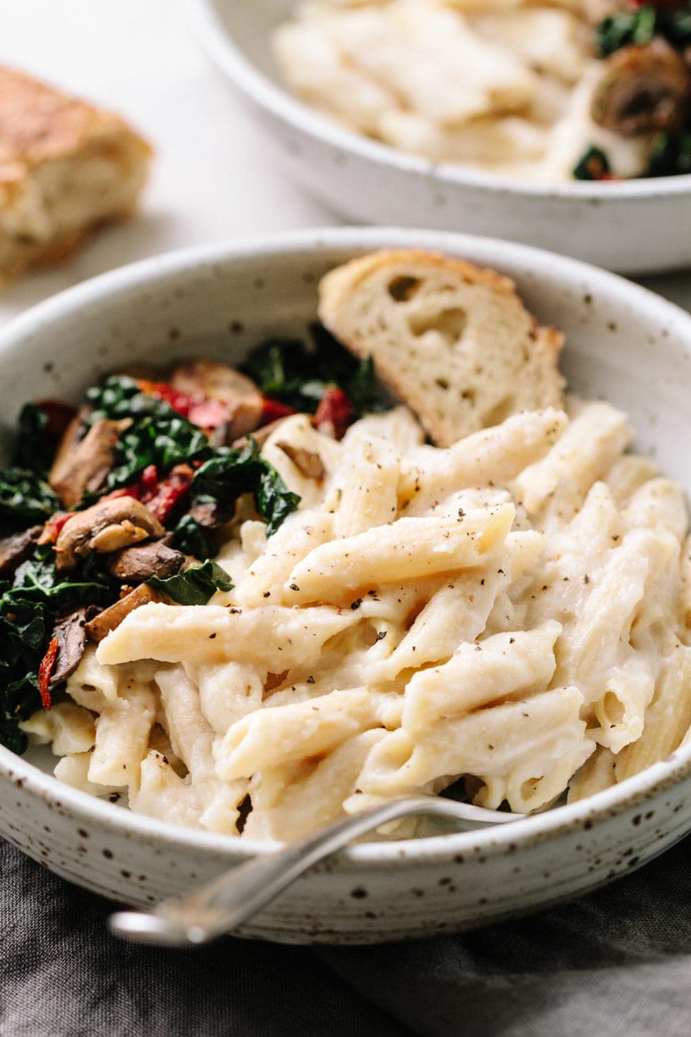 creamy white bean and cauliflower alfredo sauce with penne pasta in a bowl