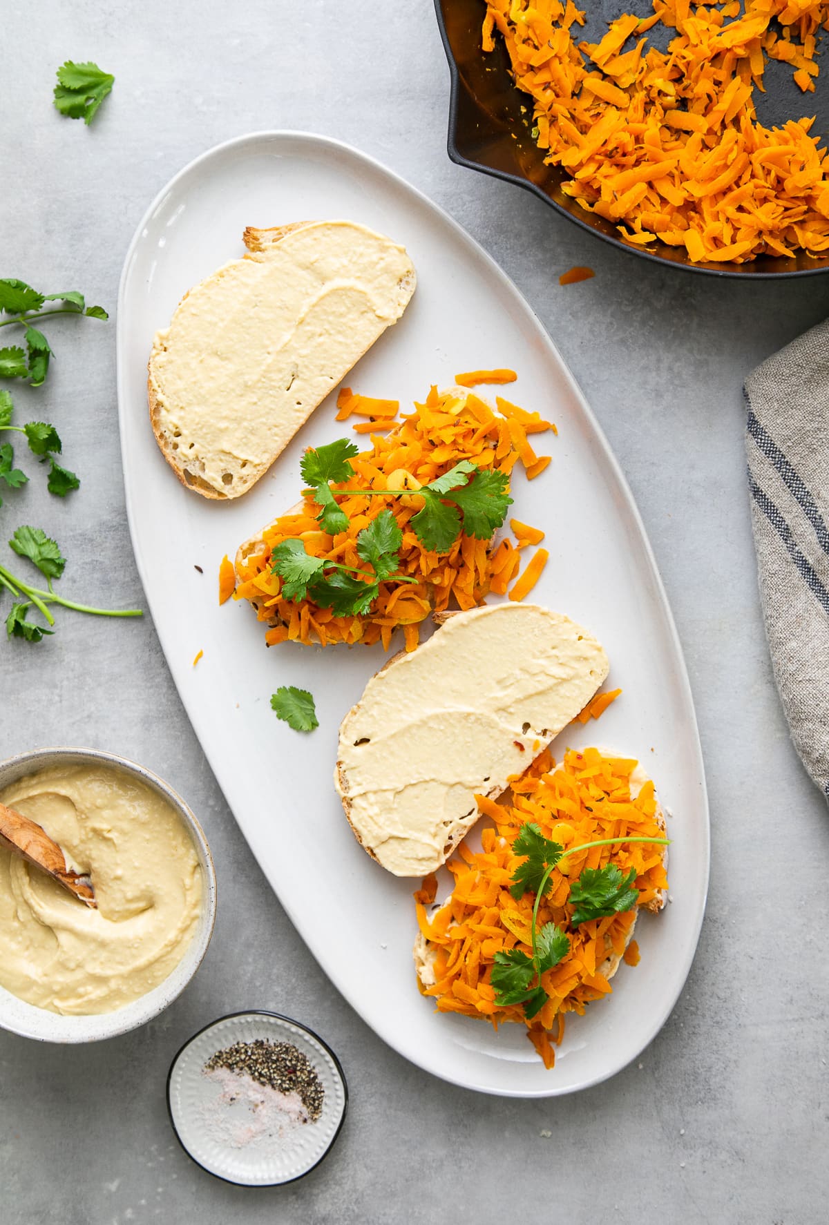 top down view showing the process of assembling carrot hummus sandwiches.