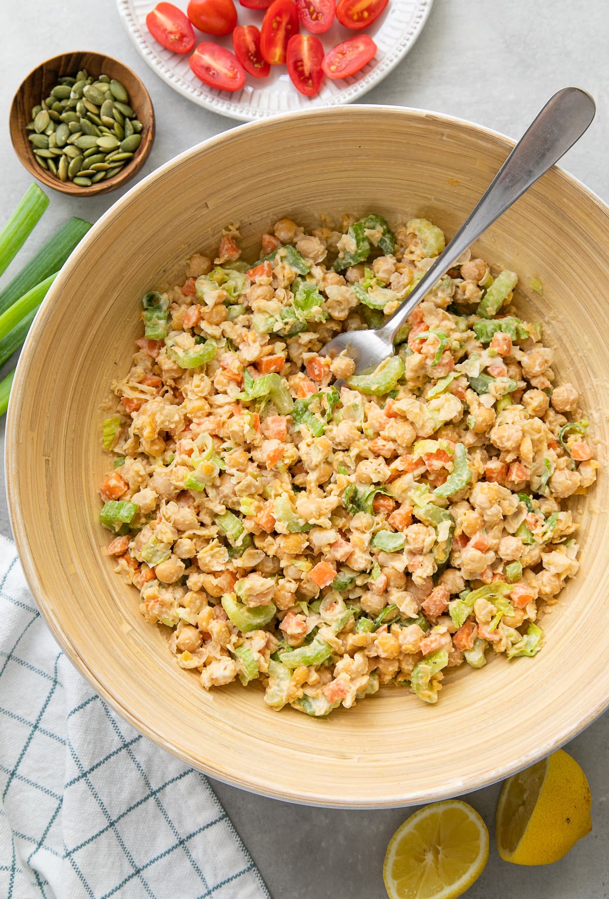 top down view of the best mashed chickpea salad in a serving bowl with items surrounding.