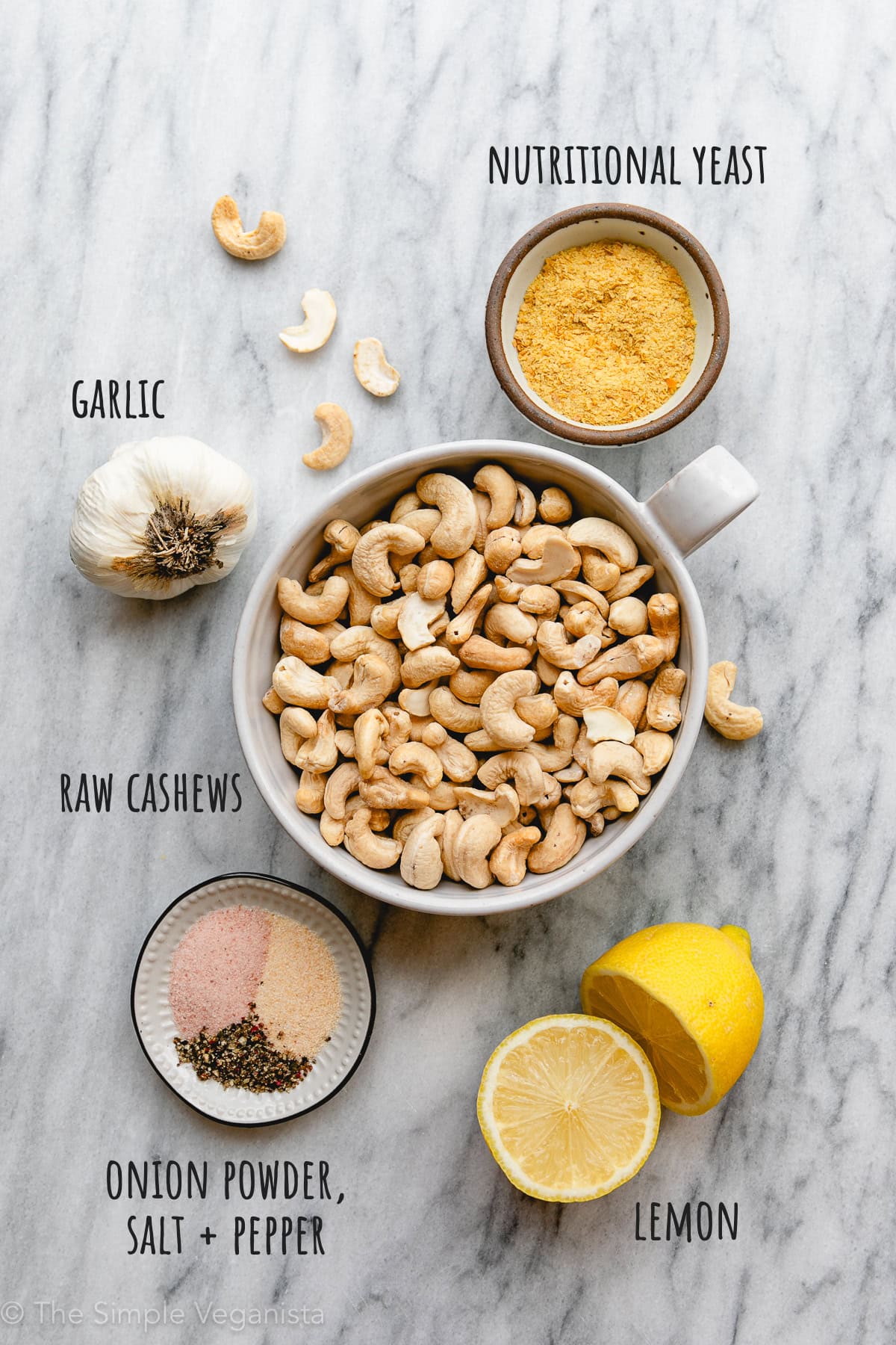 top down view of ingredients used to make vegan cashew ricotta on a marble slab.