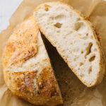 no knead bread cut in half on parchment paper