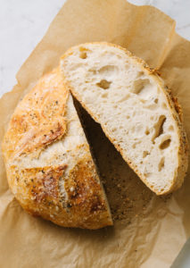 no knead bread cut in half on parchment paper