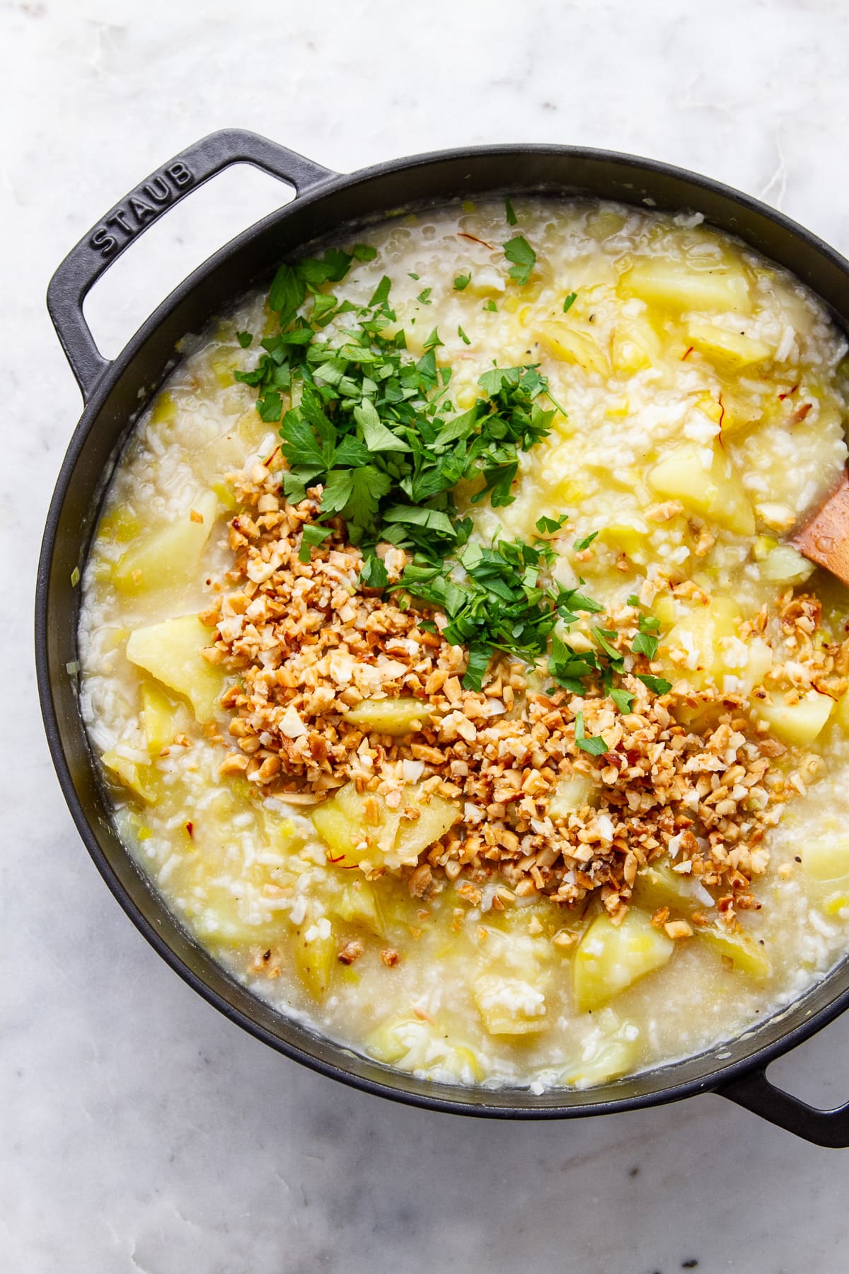 top down view of adding almonds and garlic to soup.