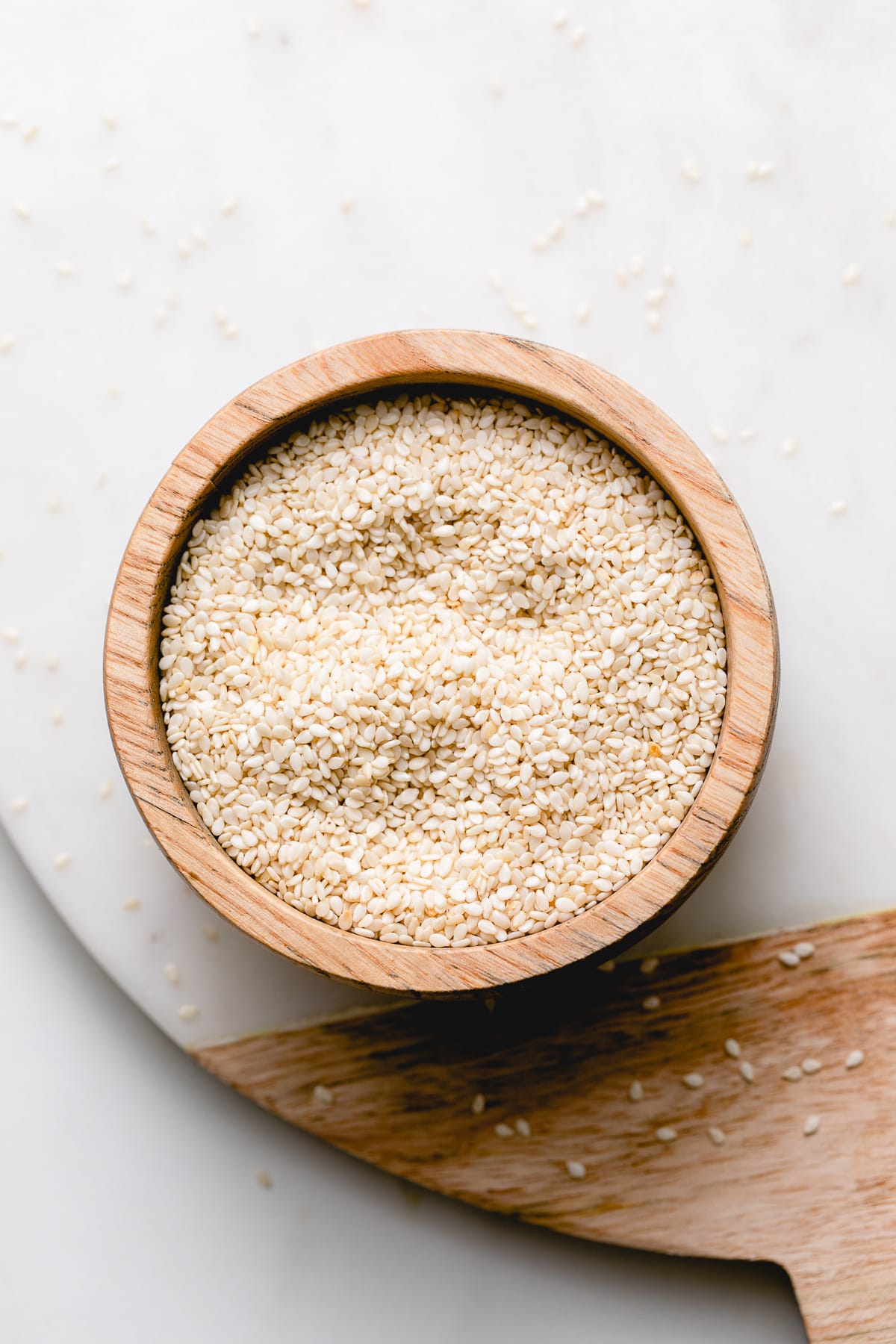 top down view of sesame seeds in a wooden bowl.