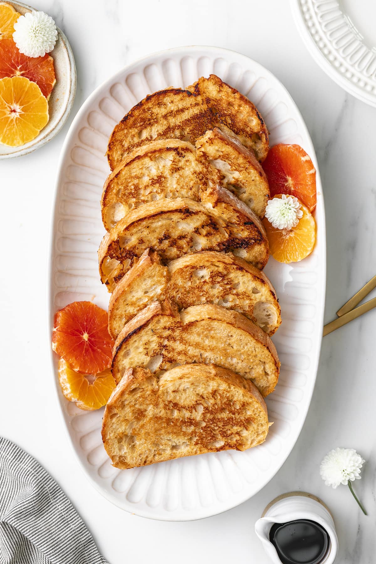 top down view of serving platter with vegan orange french toast with items surrounding.