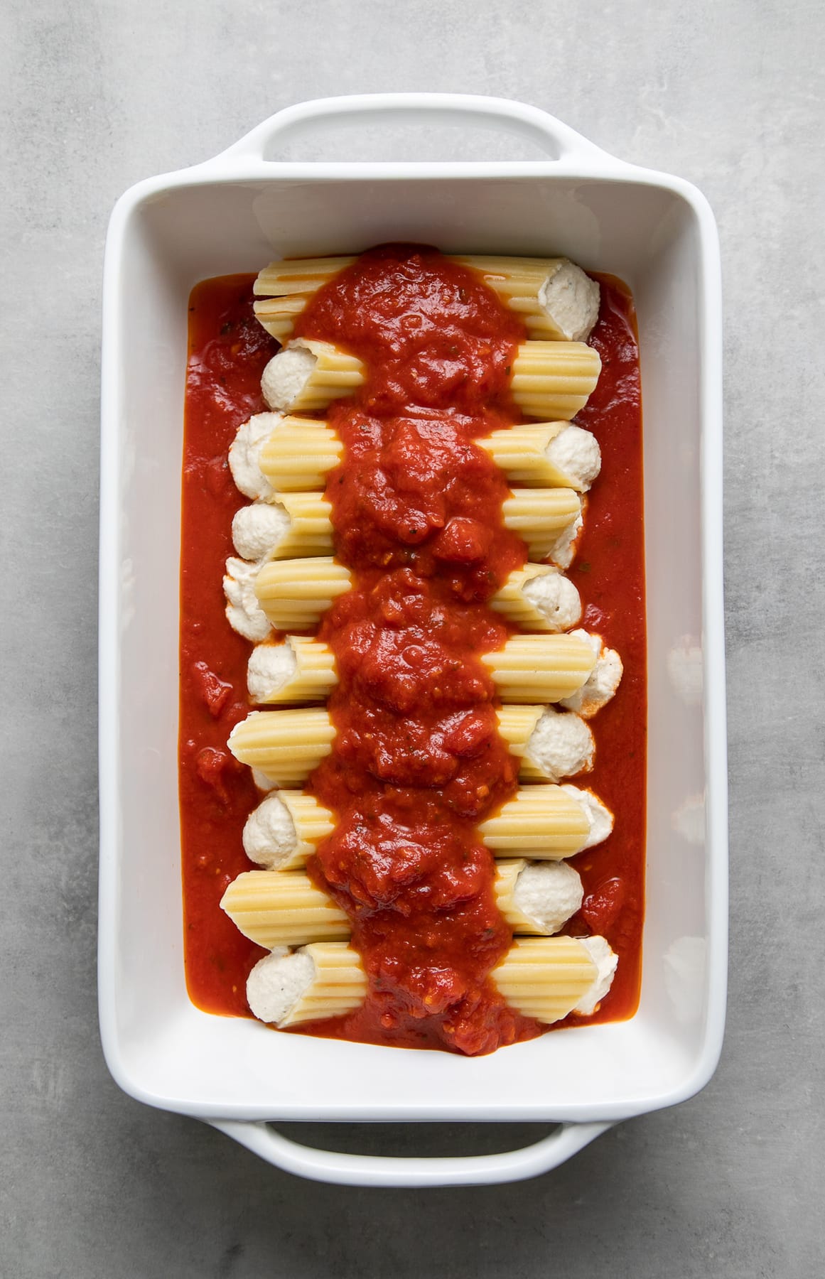top down view of prepped vegan manicotti in a rectangular baking dish before putting in the oven.