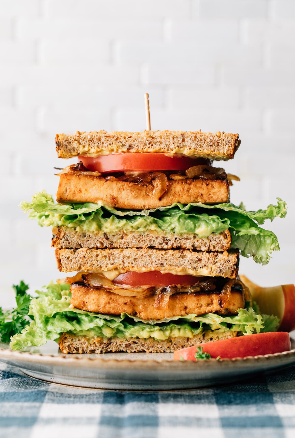 head on view of two halves of tofu sandwich stacked on a plate.