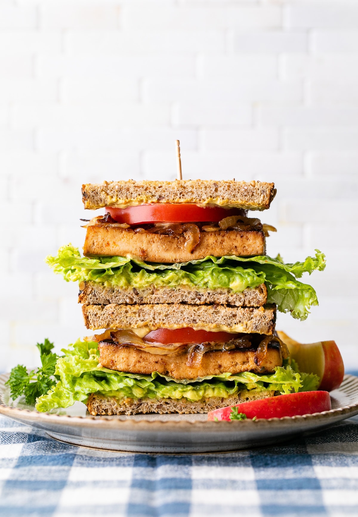 head on view of two halves of tofu sandwich stacked on a plate.
