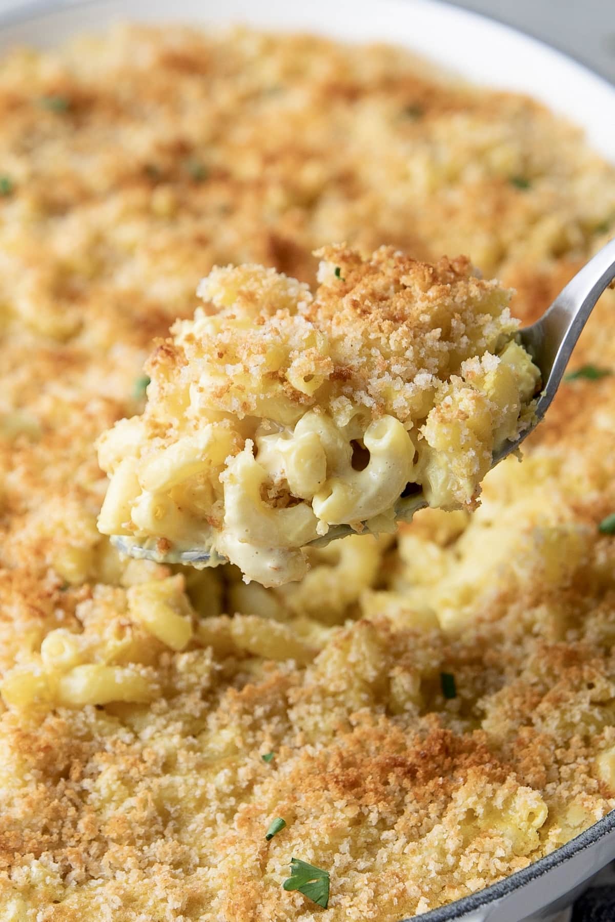 side angle view of spoonful of baked vegan mac and cheese.