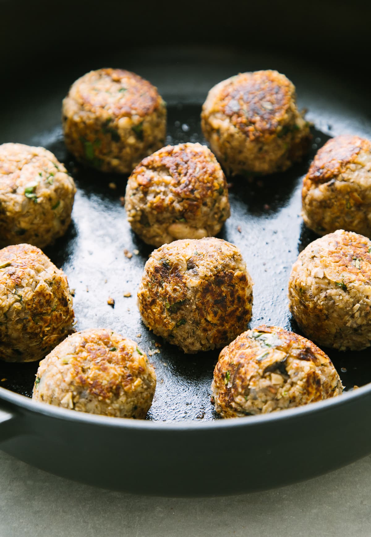 side angle view of freshly made skillet cooked vegan meatballs.