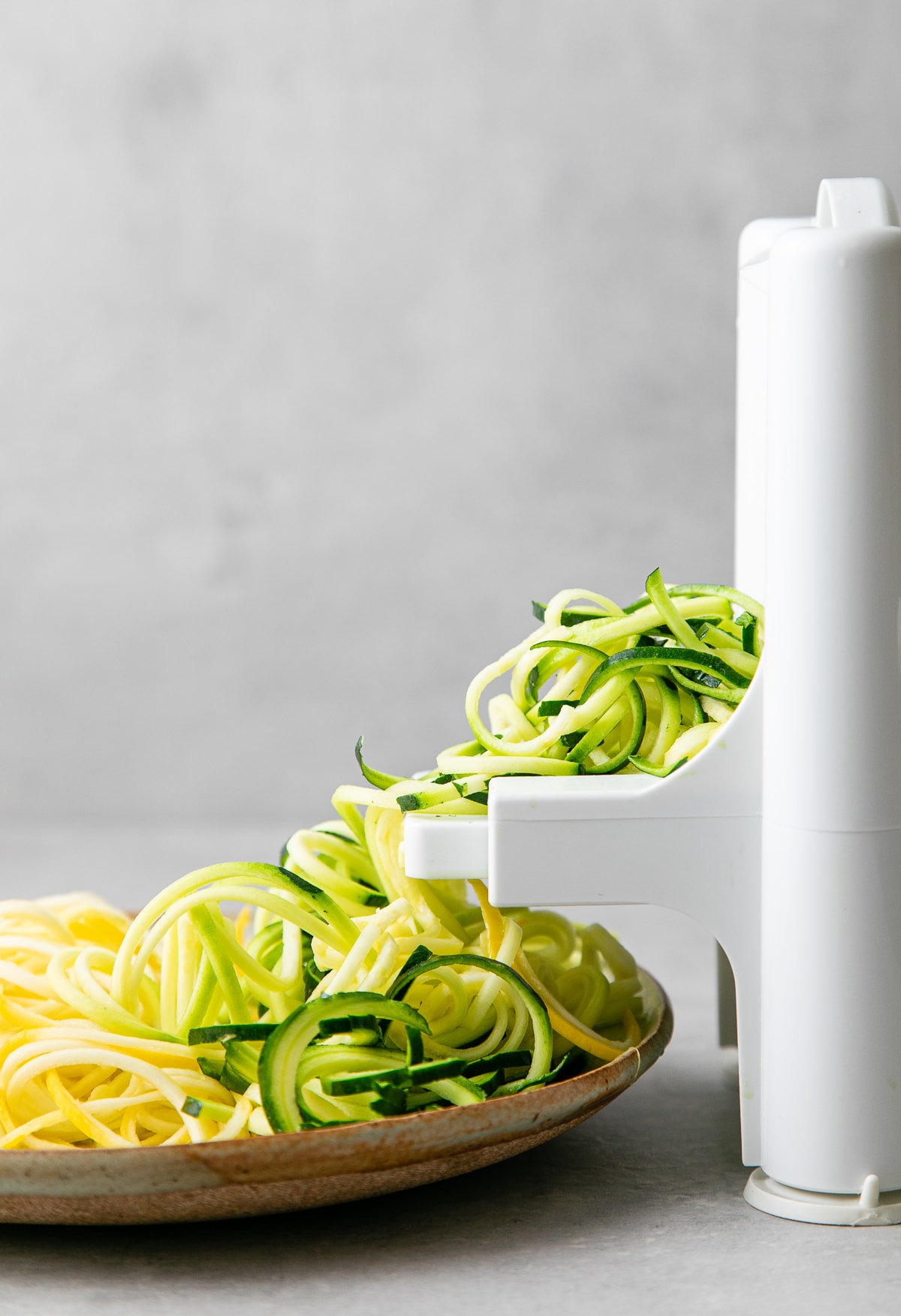 head on view of showing the process of making raw zucchini noodles.