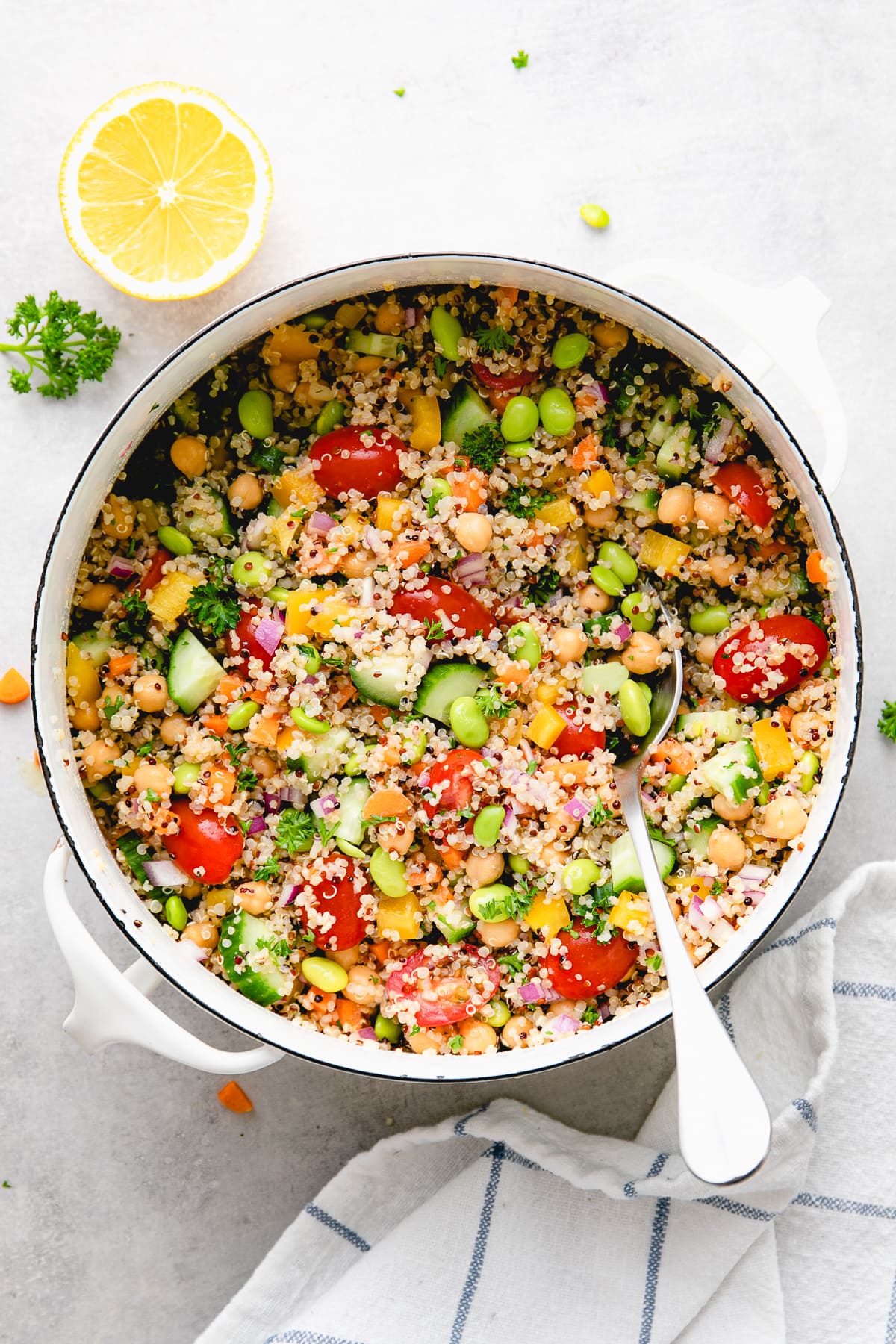 top down view of freshly made vegan quinoa salad in a pot with items surrounding.