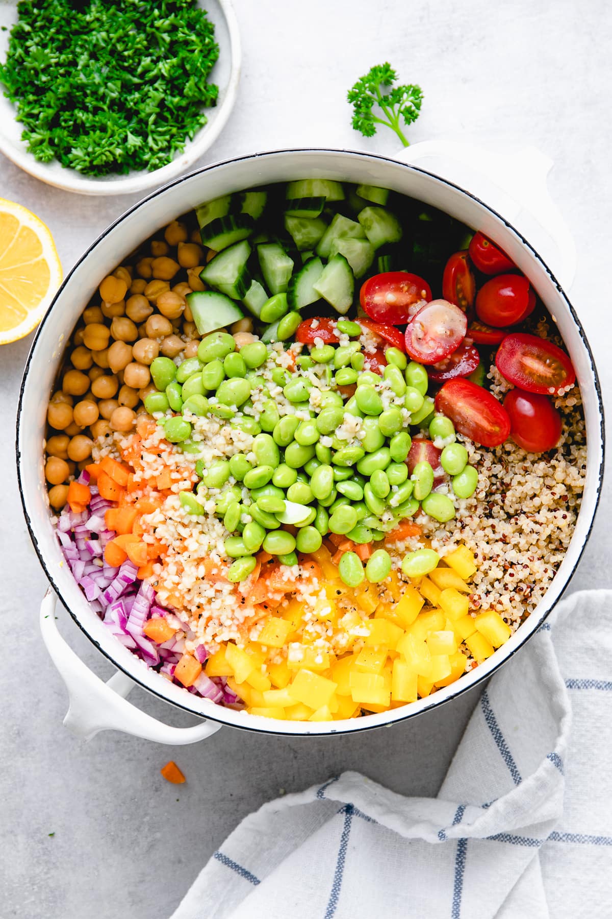 top down view of quinoa, veggies, and dressing in a pot and ready to mix.