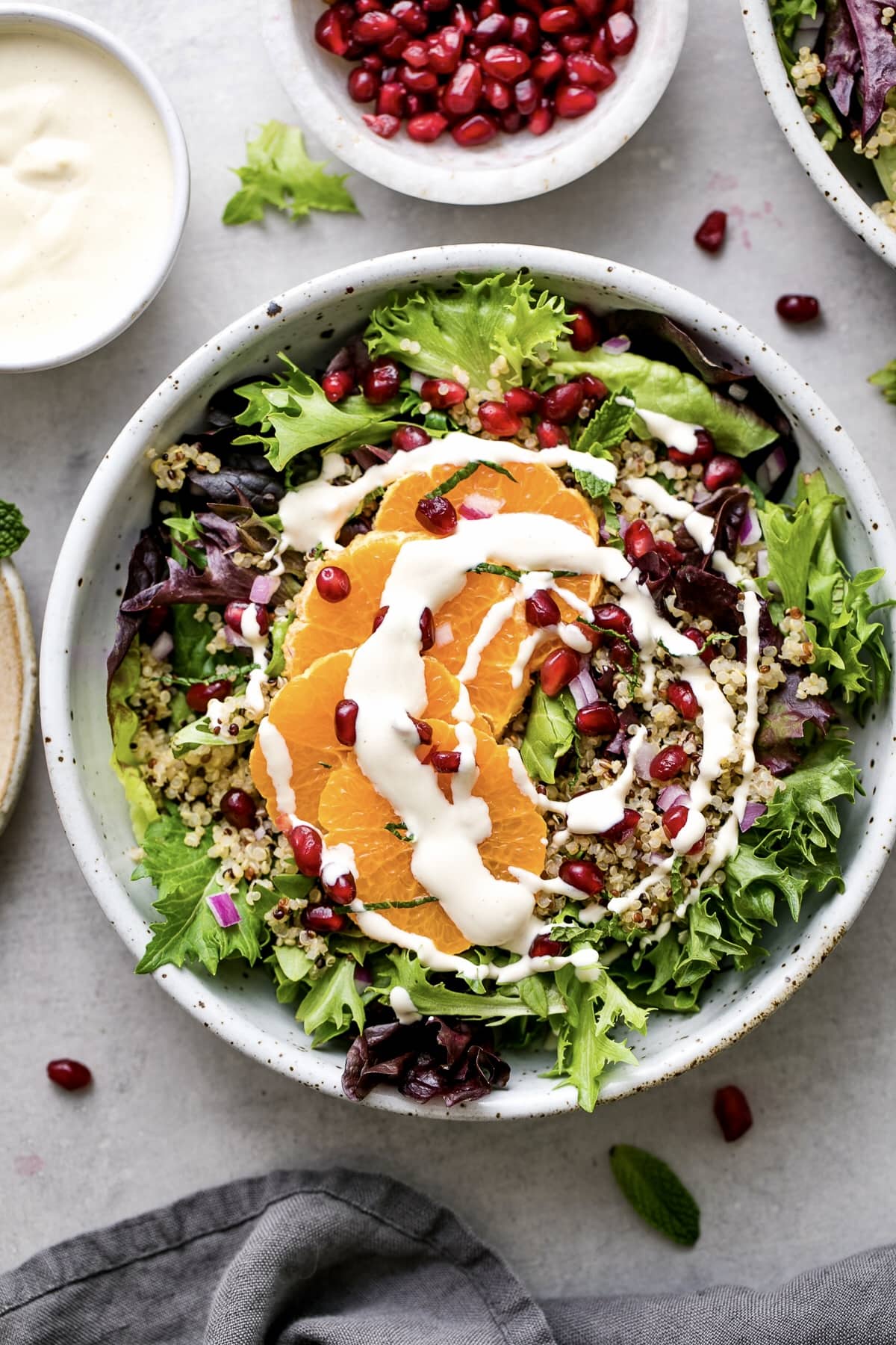 top down view of winter salad with dressing in a bowl and items surrounding.