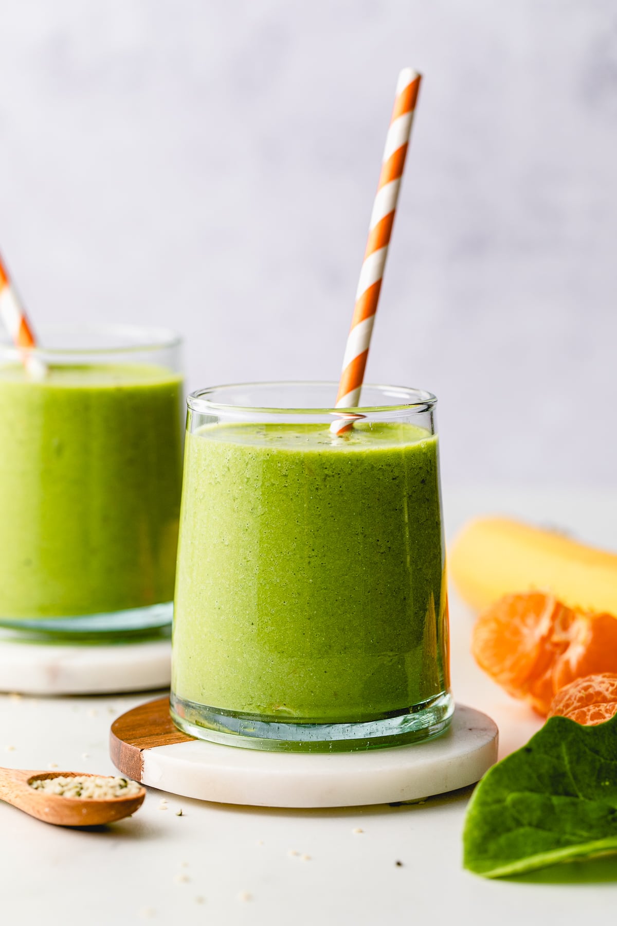 head on view of hemp smoothie in a glass with straw and items surrounding.