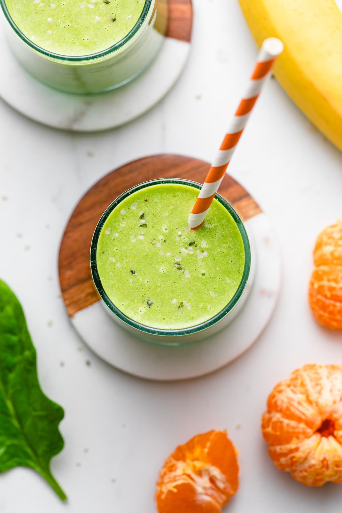 top down view of hemp smoothie in a glass with straw and items surrounding.