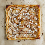 top down view of fresh baked pear tart on parchment paper.