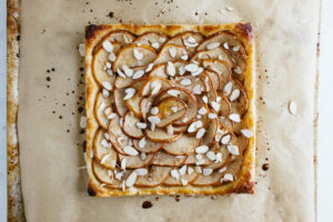 top down view of fresh baked pear tart on parchment paper.